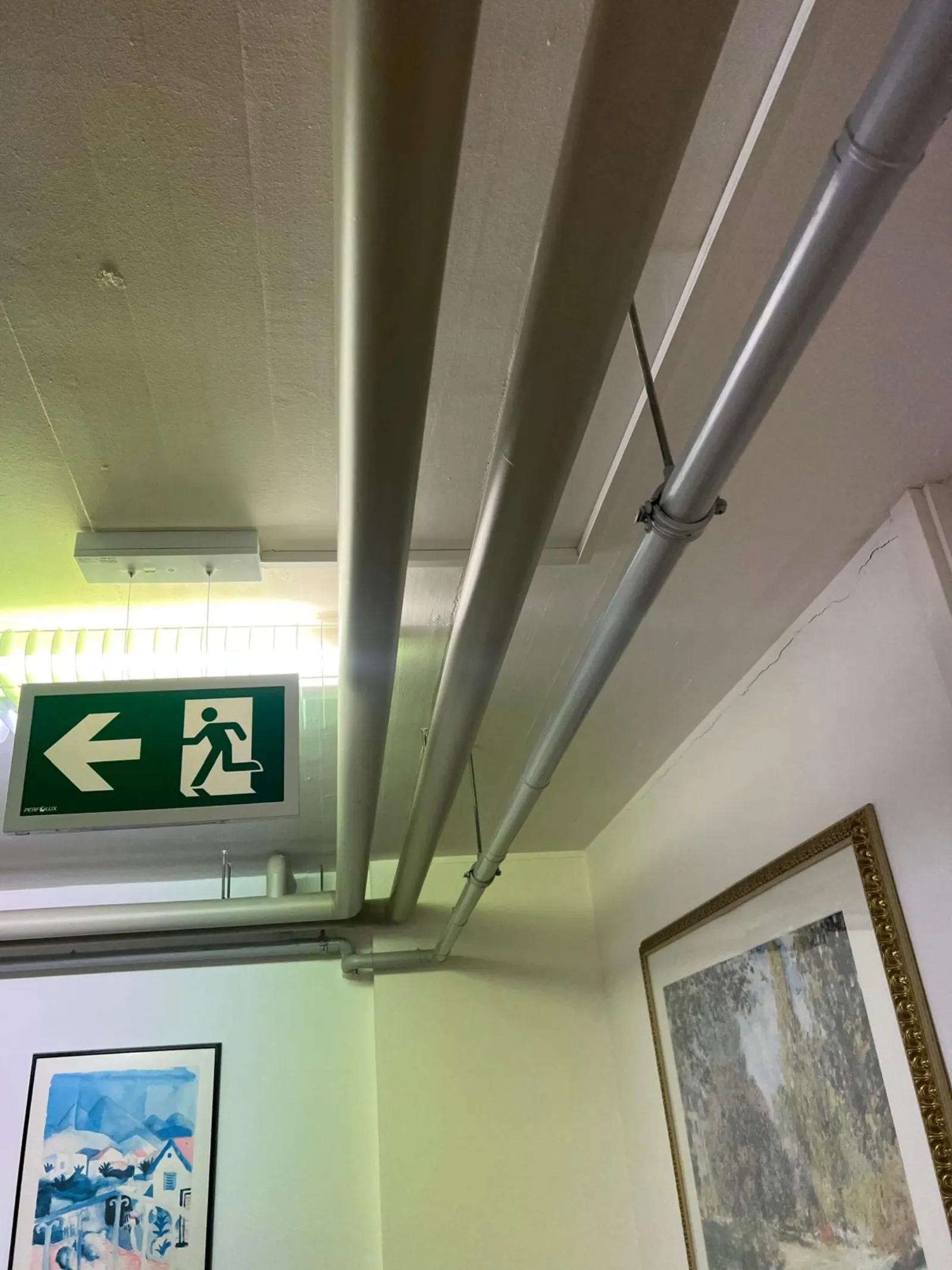 Couloir bureaux avec gaines techniques apparentes au plafond