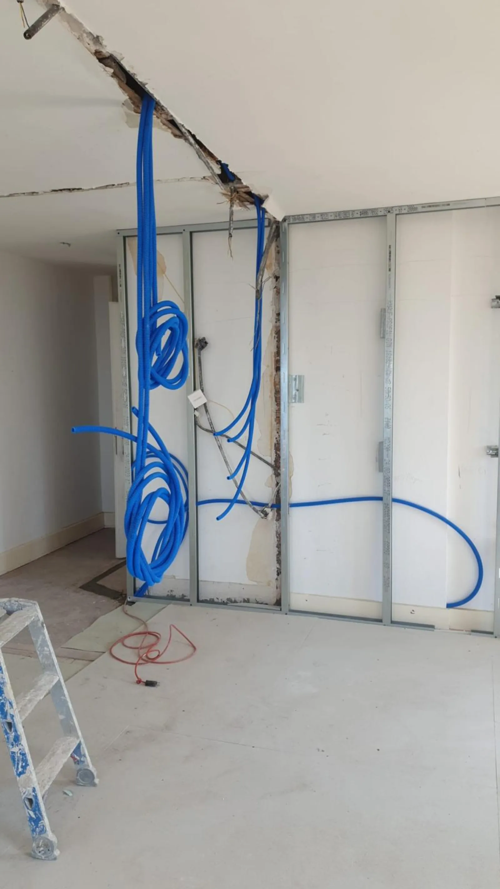 Cloisons en cours de pose avec gaines bleues — appartement Riviera