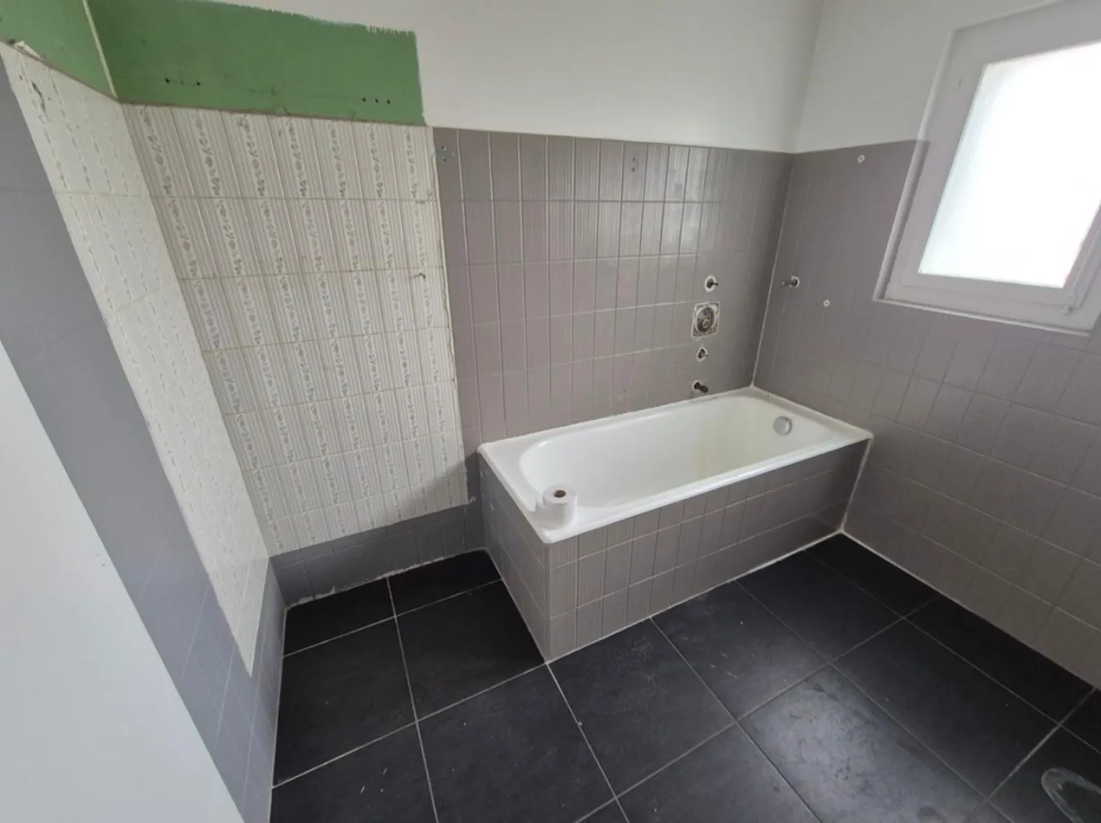 Salle de bain ancienne carrelage gris-violet avec baignoire d'origine — avant rénovation